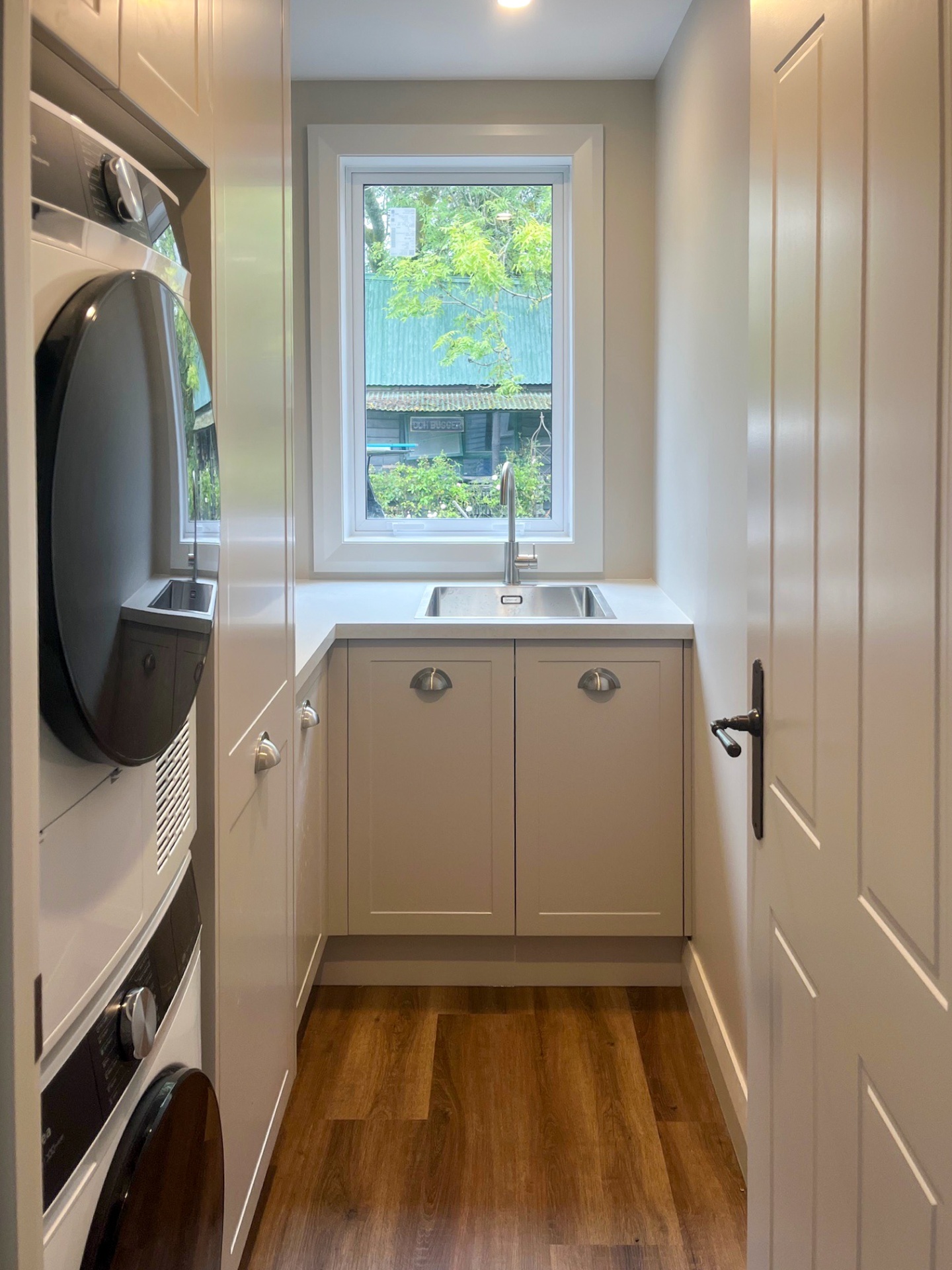 Laundry with stacked appliances and stone bench